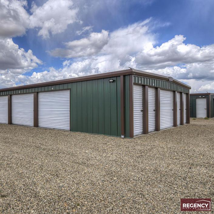 green and white mini storage building with a clouding sky