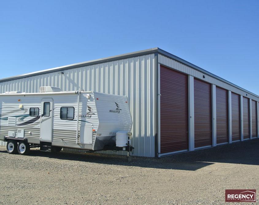 RV storage with a camper trailer posed for scale